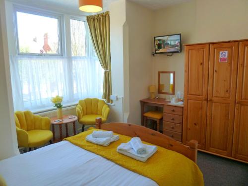 a bedroom with a bed with two towels on it at Brackenhurst Guest House in Skegness