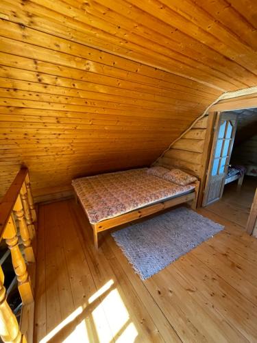an attic room with a bed in a log cabin at Oksa Puhkemaja in Võru
