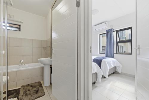 a bathroom with a bed and a tub and a sink at Gae La Rona in Gaphatshwe
