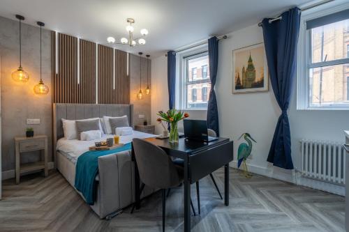 a bedroom with a bed and a table and a desk at Shoreditch Luxe in London