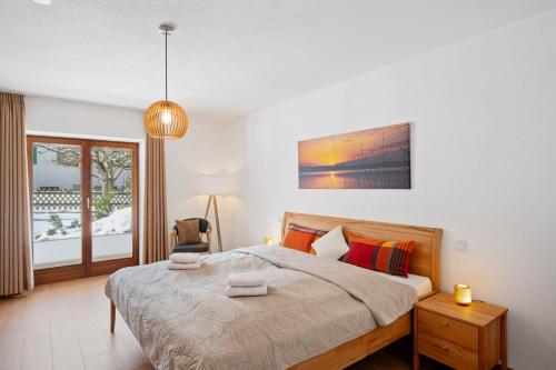 a bedroom with a large bed and a window at Alpenpanorama Bad Kohlgrub in Bad Kohlgrub