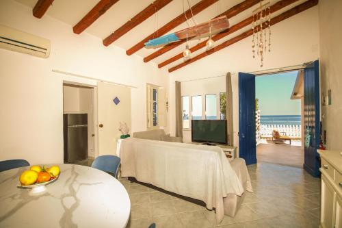 a living room with a table and a view of the ocean at Dimore di mare - Beachfront Apartments in Santa Flavia
