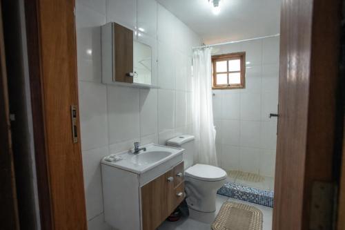 a white bathroom with a sink and a toilet at Pousada Campina do Monte Alegre in Campina do Monte Alegre