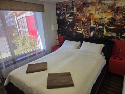 a bedroom with a large bed with two towels on it at Kotedža Tīkli in Bigauņciems