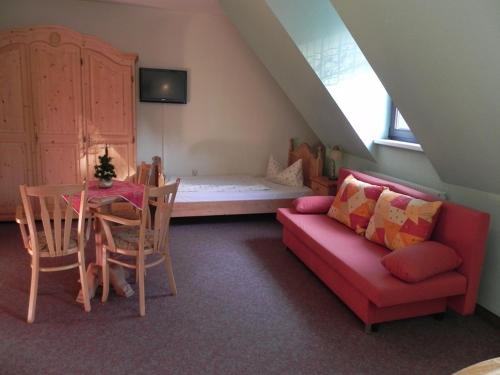 a living room with a couch and a table and a bed at Landhotel Osterlamm in Grünhain
