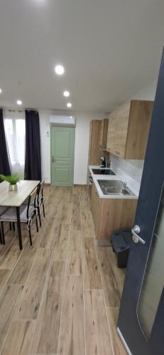 a kitchen with wooden floors and a table and a table and chairs at L'Escale Chaunoise in Chauny