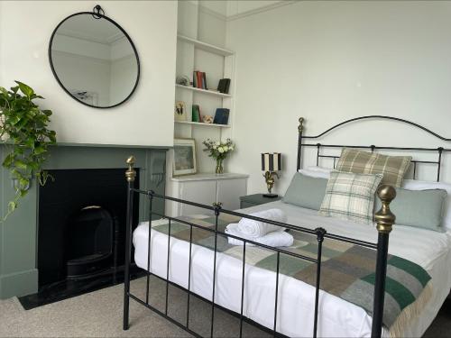a bedroom with a bed with a mirror and a fireplace at Beds at 46, Cowes in Cowes