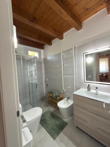 a bathroom with a toilet and a sink and a tub at Garda Green - Luxury Apartment in Lonato
