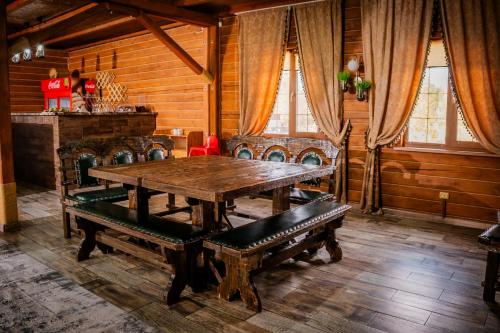 a dining room with a wooden table and benches at KokTau in Kokshetau