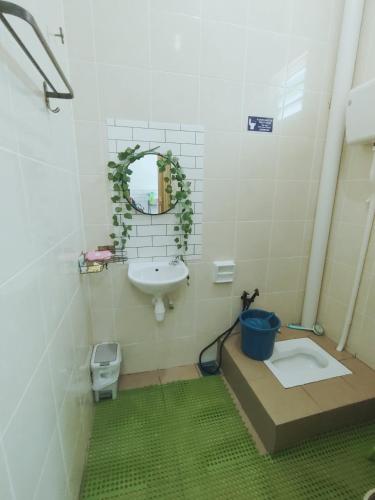 a bathroom with a sink and a toilet and a mirror at D 'Fidarez Homestay in Pendang