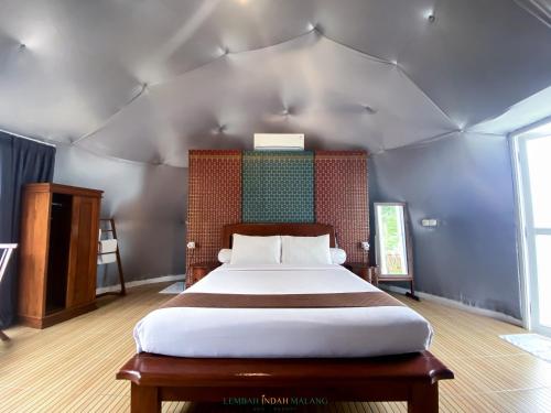 a bedroom with a large bed in a tent at Lembah Indah Malang in Gendogo