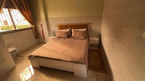 a small bedroom with a bed with a wooden headboard at Imi Ouaddar Sea View Retreat in Agadir