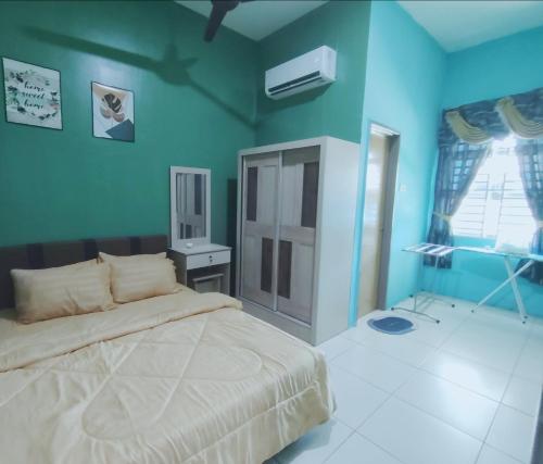 a bedroom with a bed and a blue wall at D 'Fidarez Homestay in Pendang