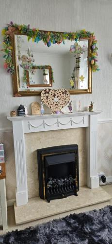 a living room with a fireplace with a mirror at Barton Beach First Floor Holiday Apartment Mablethorpe in Mablethorpe