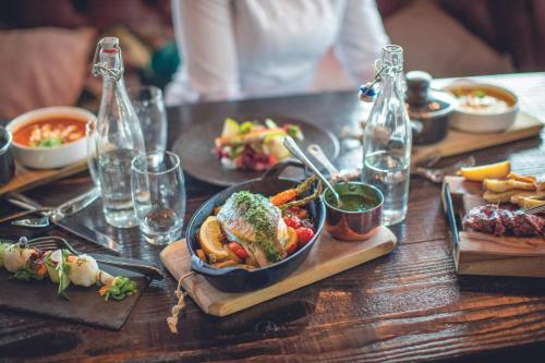 a wooden table with a plate of food on it at Leonardo Hotel Papendrecht in Papendrecht