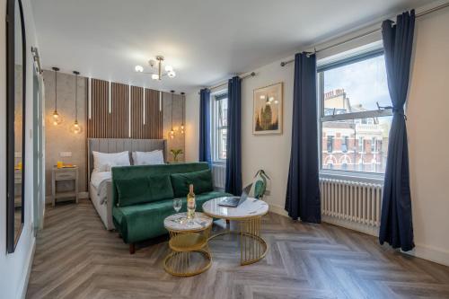 a living room with a green couch and a bed at Shoreditch Luxe in London