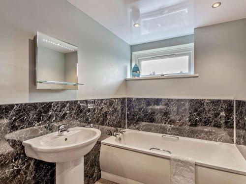 a bathroom with a sink and a bath tub at 3 Bed in Keswick oc-sz047 in Threlkeld