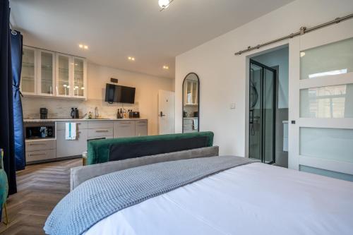a bedroom with a white bed and a kitchen at Shoreditch Luxe in London