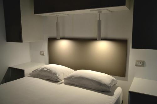 a bedroom with a bed with two white pillows at Camping 4 Cerchi Ecogreen in Lido di Fermo