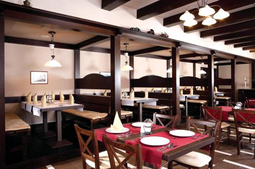 a restaurant with tables and chairs in a room at Hotel Gradina Morii in Sighetu Marmaţiei