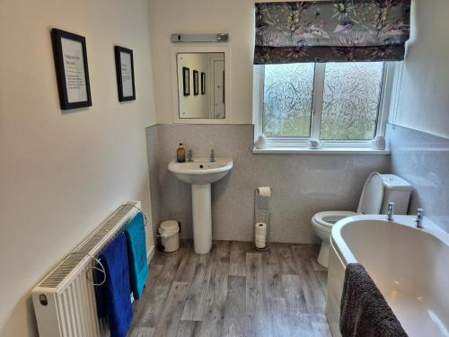 a bathroom with a tub and a sink and a toilet at 3 Bed in Dumfries oc-77430 in Auldgirth