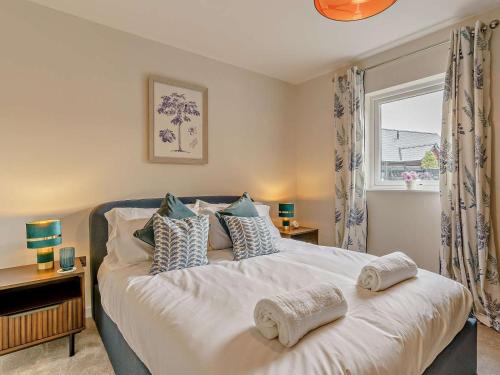 a bedroom with a bed with pillows and a window at 2 Bed in Swansea oc-91726 in Killay