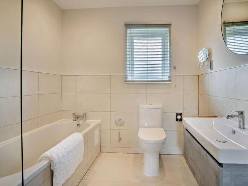 a bathroom with a tub and a toilet and a sink at 3 Bed in Swansea oc-91721 in Killay