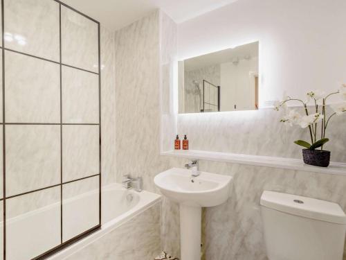 a bathroom with a sink and a toilet and a mirror at 2 Bed in Keswick oc-91901 in Keswick