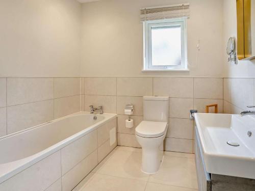 a bathroom with a tub and a toilet and a sink at 3 Bed in Swansea oc-91722 in Killay