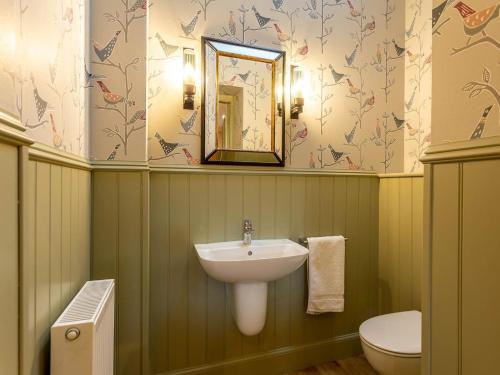 a bathroom with a sink and a toilet and a mirror at 1 Bed in Forres oc-78430 in Forres