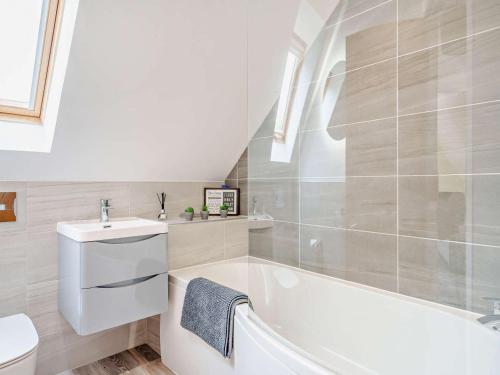 a white bathroom with a tub and a sink at 3 Bed in Callander oc-79359 in Callander
