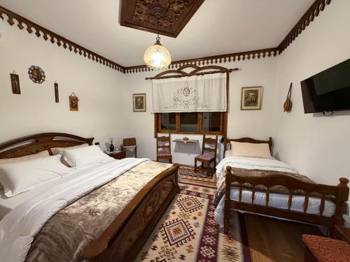 a bedroom with two beds and a television in it at Hotel Boutique Ergjeria in Gjirokastër