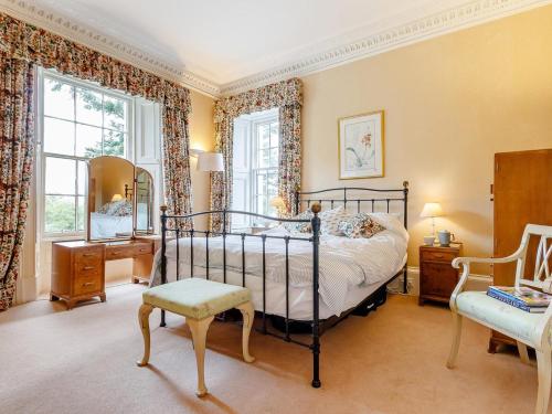 a bedroom with a bed and a chair and windows at 5 Bed in Blairgowrie oc-ca409 in Cray