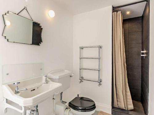 a white bathroom with a toilet and a sink at 4 Bed in Leyburn oc-g0008 in Gammersgill