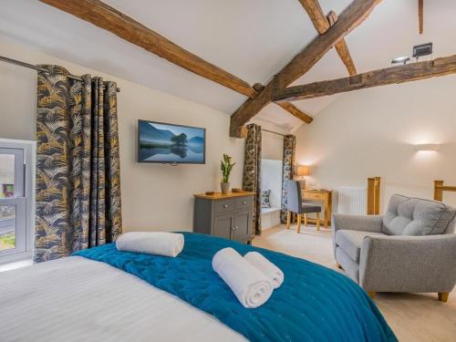 a bedroom with a large bed and a chair at 1 Bed in Grange-over-sands oc-78659 in Cartmel