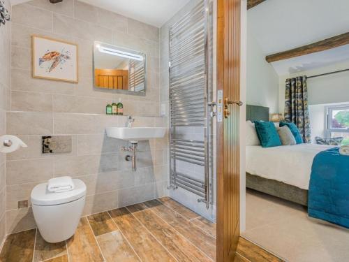 a bathroom with a toilet and a sink and a bed at 1 Bed in Grange-over-sands oc-78659 in Cartmel