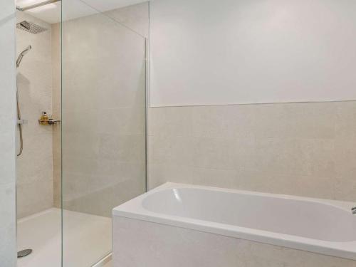 a bathroom with a shower and a white bath tub at 3 Bed in Swansea oc-91729 in Killay