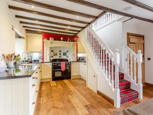 a kitchen with wooden floors and white walls and a staircase at 2 Bed in Drumnadrochit oc-ca315 in Drumnadrochit