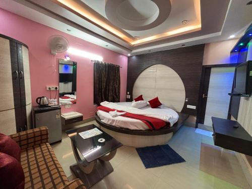 a bedroom with a bed and a bathroom with a sink at Hotel Kep's - A Business Class Hotel in Contai