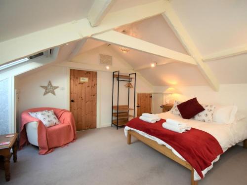 a bedroom with a large bed and a chair at 3 Bed in Penrith oc-74159 in Shap