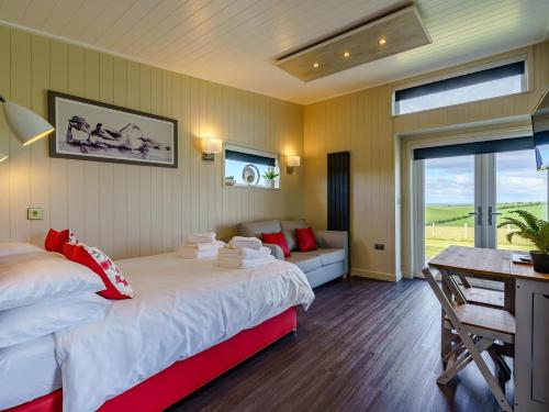 a bedroom with two beds and a desk and a table at 1 Bed in Girvan oc-78071 in Girvan