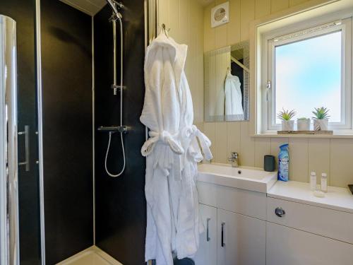 a bathroom with a shower and a white robe at 1 Bed in Girvan oc-78071 in Girvan