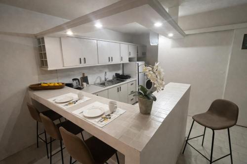 a kitchen with a counter with chairs and a kitchen island at Modern & Cozy Studio for 2 in Saronida Steps from the Beach in Saronida