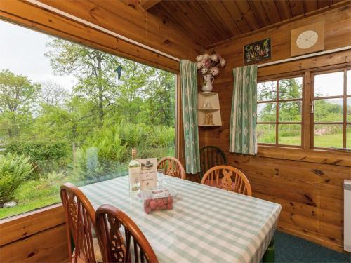 a dining room with a table and chairs in a cabin at 2 Bed in Killin oc-ca351 in Ardeonaig