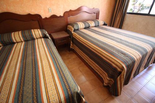 two beds sitting next to each other in a room at Hotel Isabel I in Oaxaca City