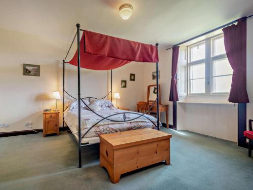 a bedroom with a canopy bed and a wooden table at 2 Bed in Lochgilphead oc-ag577 in Kilmartin