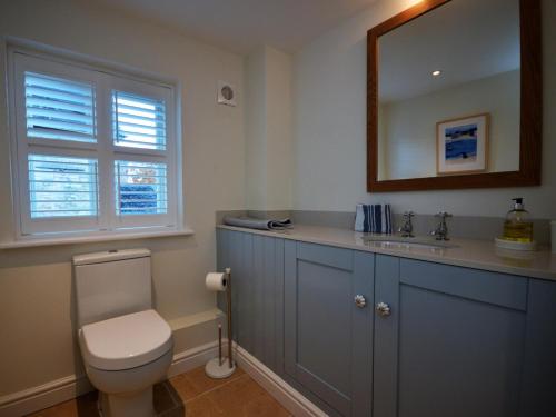 a bathroom with a toilet and a sink and a mirror at 3 Bed in Tetbury oc-44955 in Tetbury