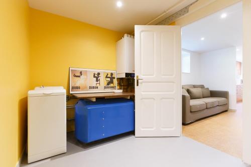 - un salon avec une porte blanche et un canapé dans l'établissement Appartements - Chez Alice, à Salies-de-Béarn