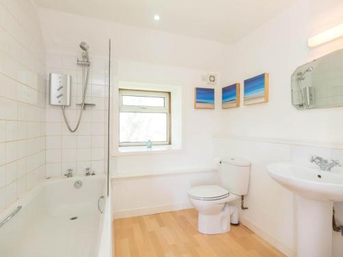 a white bathroom with a toilet and a sink at 2 Bed in Gairloch oc-ca137 in Big Sand