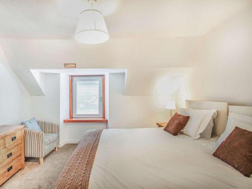 a bedroom with a large white bed and a window at 4 Bed in Ballindalloch oc-46162 in Tomintoul